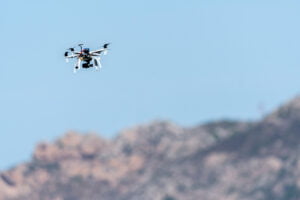 drone with camera hovering over mountains