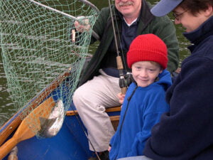 young boy with fish caught in the net